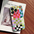 A retro-inspired colorful plaid phone case lying on art magazine, highlighting the distressed texture and artistic vibe.