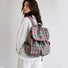 Side view of a model styling the pink and green plaid aesthetic school bag over one shoulder.