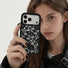 Female model holding the black rose lace clear phone case near her face showing intricate lace detail.