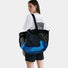 Back view of a model carrying the blue and black double-sided tote bag.