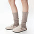 Model wearing a pair of khaki Ribbed Knit Leg Warmers, easy for travel days and daily comfort.