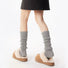 Model wearing a pair of light gray Ribbed Knit Leg Warmers, ideal for everyday outfits and sneakers.