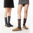 Two models wearing Ribbed Knit Leg Warmers,one black and one brown.