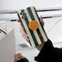Back view of the phone case held in hand; ergonomic circular grip offers secure one-handed device use.