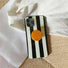 Close-up of stripe case on a wooden surface; chic minimalist design suited for aesthetic workspace decor.