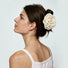 Sideview of a model showing a beige rose hair claw clip holding hair up.