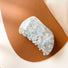 Flat lay of Shell hair claw in blue crystal, great for everyday styling and gifting.