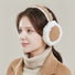 Model wearing brown sherpa polyester earmuffs with white trim, great for winter looks and travel days.