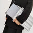 Model carrying a Silver padded polyester laptop sleeve handheld, easy for commuting.