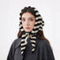 Model wearing a black and white striped 100% wool triangular scarf, tied under her chin.