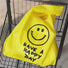 Bright yellow foldable shopper bag with black smiley face and HAVE A HAPPY DAY text.