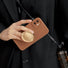 Model holding brown Solid Color Case. Showcasing a minimalist matte finish and integrated stand.