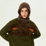 Woman wearing a speckled brown balaclava with a matching olive green sweater for a cozy winter set.