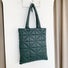 Angled view of Starburst Quilted Shoulder Bag in green, great for everyday carry and travel.