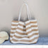 Close-up of Beige and white striped canvas tote bag with long straps, next to a cream baseball cap, ideal for errands.