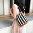 Model carrying a brown striped bag on the shoulder, great for daily carry and travel.