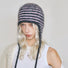 Front view of a model wearing the pink and dark grey striped earflap hat for a cozy look.