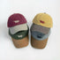 Two stacks of Sun Day cotton blend caps in maroon, beige, olive, yellow, gray, and brown for daily casual wear.