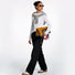 Model in black and white casual outfit, holding the tote bag as foldable clutch, full-body shot.
