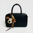 Super Dog bag charm hanging on a black handbag.