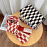 Front view of Thick wool checkered scarves in red/white, black/white, green/white, and blue/white, folded on a wooden.