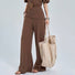 Model carrying khaki striped tote by hand; spacious design perfect for travel essentials and gym gear.