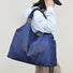 Model carrying a Touch Nylon Weekend Bag in blue, easy for commuting and weekends.
