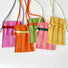 Front view of Five vivid knit polyester mini bags in pink, orange, green, and yellow with adjustable crossbody straps.