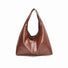 Caramel waxed leather shoulder bag on a white background