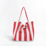 Flat lay of Wide Stripe Canvas Tote Bag in red, great for everyday carry and travel.