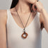 Model wearing Wild Grace Geometric Pendant Necklace in Brown.