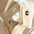 Angled view of two paris of ribbed wool C socks in khaki and beige.