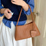 Model carrying a tan bag handheld, easy for commuting and weekends.