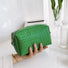 Model holding a green woven makeup bag in hand, easy to carry for travel and errands.