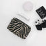 Flat lay of Zebra Print Makeup Bag in black, ideal for travel makeup and toiletries.
