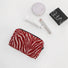 Close-up of Zebra Print Makeup Bag in red, easy to pack for trips and daily use.