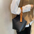 Model carrying a black Balloon Bucket Bag handheld, great for daily carry and travel.