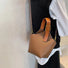 Angled view of model carring a tan Balloon Bucket Bag as crossbody bag, easy for commuting and weekends.