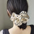Model wearing Black Trim Satin Scrunchie with butterfly pattern, easy for workdays and special occasions.