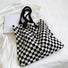 Classic black and white checkered knitted tote bag, a timeless essential for any outfit.
