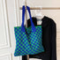 Blue and green checkered knit tote hanging on a rack, perfect for a minimalist wardrobe.