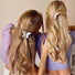 Two models wearing butterfly hair claw in white and pink , easy for workdays and special occasions.