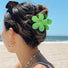 Model wearing a Candy Flower Hair Claw in green, ideal for quick updos and ponytails.