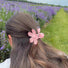 Model wearing a Candy Flower Hair Claw in pink, great for everyday styling and gifting.