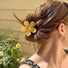 Model wearing a Candy Flower Hair Claw in yellow, easy for workdays and special occasions.