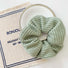 Angled view of Candy Knitted Scrunchie in mint green, great for everyday styling and gifting.
