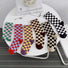 Front view of six pairs of colorful checkerboard socks in cotton-acrylic blend.