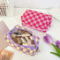 Open view of a purple checkered knit pouch filled with cosmetics; highlighting the spacious interior for travel.
