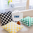 Angled view of three Checkerboard Pillow Covers on couch, easy for everyday use.