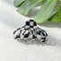 Flat lay of checkered hair claw hair claw clip in lantern shape, great for everyday styling and gifting.